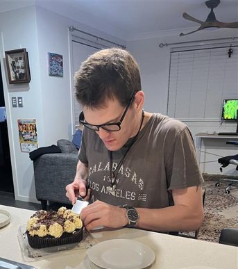 A participant decorating a cake at home